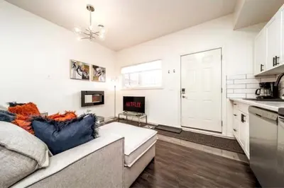 a living room with a couch and a kitchen at 3BDRM Winter Haven - King Beds - Fireplace - Garage in Edmonton