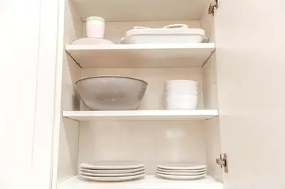 a cupboard with plates and dishes in it at 3BDRM Winter Haven - King Beds - Fireplace - Garage in Edmonton