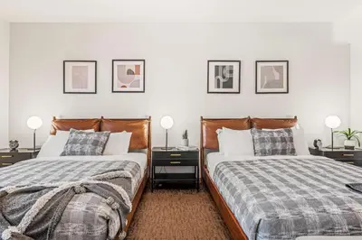 two beds sitting next to each other in a bedroom at Luxury 1750sf Condo In DT Canmore Sleeps 10 in Canmore