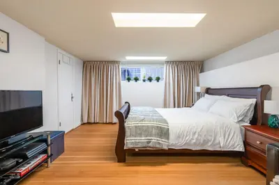a bedroom with a bed and a flat screen tv at BudgetWise Semi-Basement near Airport, UBC, Downtown in Vancouver in Vancouver