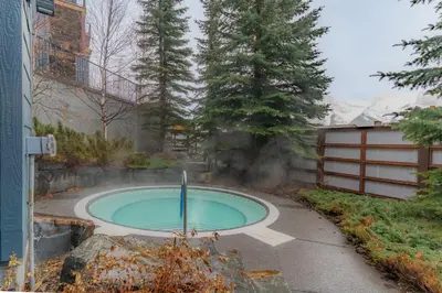 a small pool with a fountain in a yard at Corner Mountain View Retreat 2 Kings w Patio in Canmore