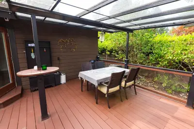 a patio with a table and chairs on a deck at Luxury Home by White Rock in Surrey