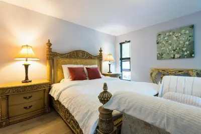 a bedroom with a bed and a chair and two lamps at Luxury Home by White Rock in Surrey