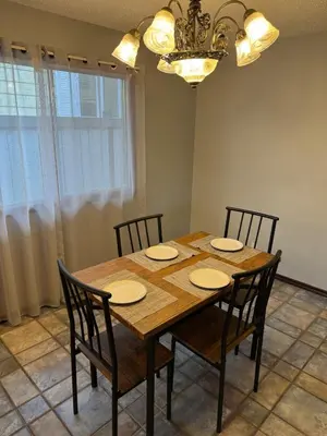 a dining room table with four chairs and a chandelier at Fully furnished House near GrayNuns, Millwoods in Edmonton
