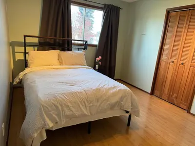 a bedroom with a bed and a large window at All what you need in a House near GrayNuns, Millwoods in Edmonton