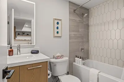 a bathroom with a sink and a toilet and a tub at King Beds Fire Place New Build in Canmore