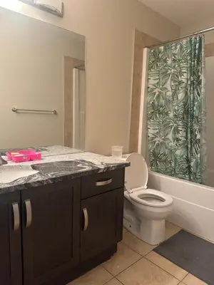 a bathroom with a toilet and a shower curtain at Private room in Edmonton