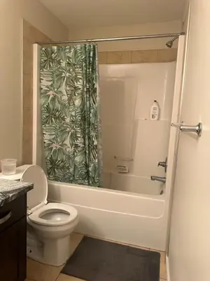 a bathroom with a toilet and a shower curtain at Private room in Edmonton