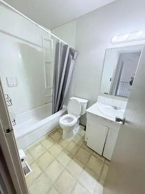 a white bathroom with a toilet and a sink at Private room in Edmonton