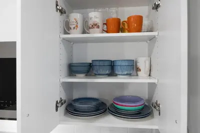 a shelf filled with plates and cups and bowls at luxury Play House Sleeps 12 Keswick in Edmonton
