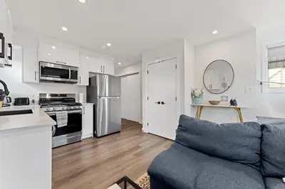 a kitchen and living room with a blue couch in a room at Modern garden suite with parking in Edmonton