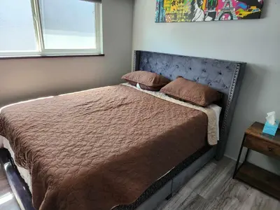 a bedroom with a bed with a brown bedspread and a window at Vancouver house 3 bedrooms and balcony Perfect for your business trip to Vancouver in Vancouver