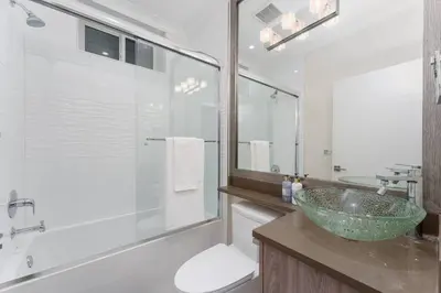a bathroom with a sink and a glass shower at New Modern 2BR Suite near UBC Pacific Spirit Park in Vancouver