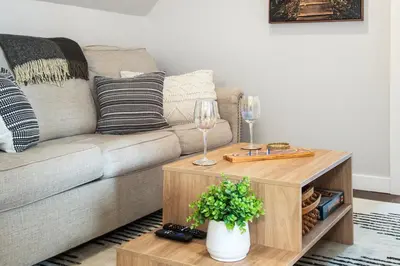 a living room with a couch and a table with wine glasses at The Loft at Marble Place a Cozy Family Retreat in Courtenay