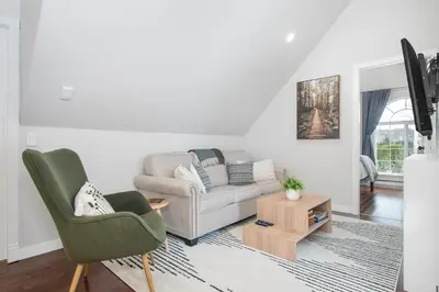 a living room with a couch and a table at The Loft at Marble Place a Cozy Family Retreat in Courtenay