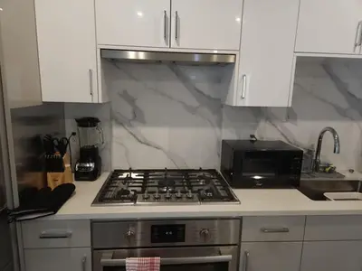 a kitchen with a stove top oven next to a microwave at Vancouver Family Condo 2 Bedrooms 2 Baths Near UBC & Parks in Vancouver
