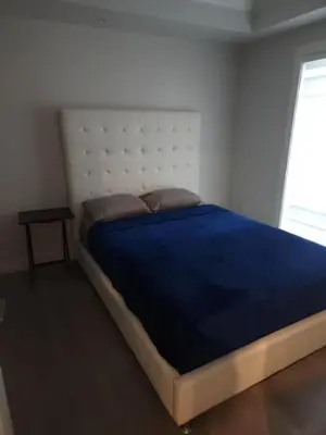 a bedroom with a large bed with a blue blanket at Vancouver Townhouse 2 Queen Beds Kitchen Street Parking - Perfect for Families in Vancouver