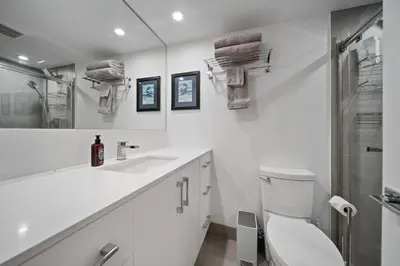 a white bathroom with a toilet and a sink at The Alpine Alcove w Pool & Hot Tub in Whistler