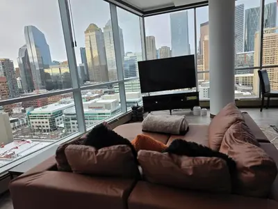 a living room with a couch in front of a large window at Breath-Taking-View-5 Guest DTskyline-18th Floor in Calgary