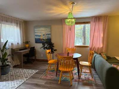 a living room with a table and chairs and a couch at Bragg Creek Vacation Estate with hot tub, sauna, pool table, karaoke, private pond and forest trails in Bragg Creek