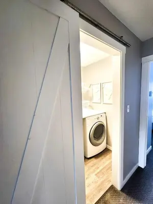 a door to a laundry room with a washing machine at Modern Lake City Getaway in Penticton