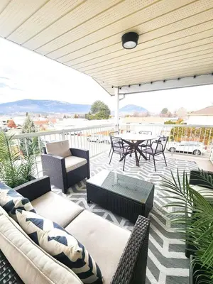 a patio with couches and a table and chairs at Modern Lake City Getaway in Penticton