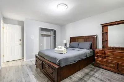 a bedroom with a large bed and a dresser at Comfortable Family Home,South Granville in Vancouver