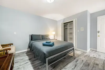 a bedroom with a bed with blue towels on it at Comfortable Family Home,South Granville in Vancouver