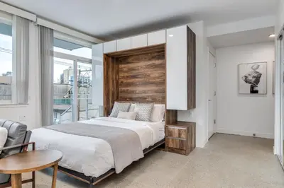 a bedroom with a large bed with a wooden headboard at Modern Downtown Studio Bedroom Walk Everywhere in Vancouver