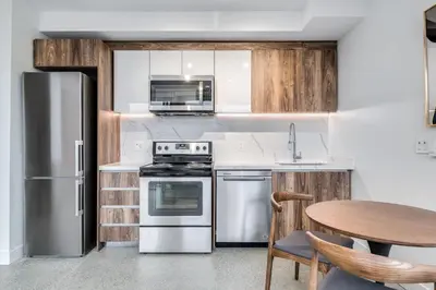 a kitchen with stainless steel appliances and a table at Modern Downtown Studio Bedroom Walk Everywhere in Vancouver