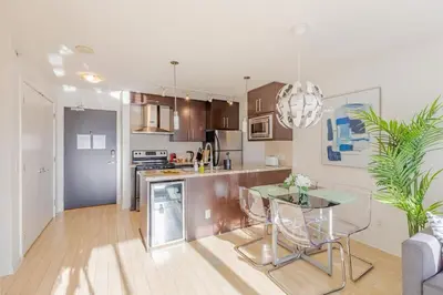 a kitchen and living room with a table and chairs at Downtown Suite with Parking, Pool, Gym in Vancouver