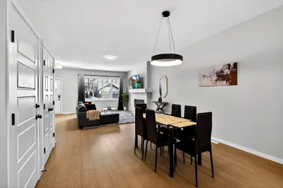 a dining room and living room with a table and chairs at modern 3bedroom space sleeps 6 free parking in Edmonton