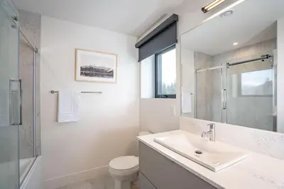 a bathroom with a sink and a toilet and a shower at Qs Hideaway in Mackenzie Village in Revelstoke