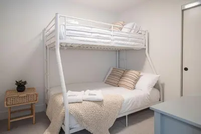 a bedroom with a white bunk bed with towels on it at Qs Hideaway in Mackenzie Village in Revelstoke