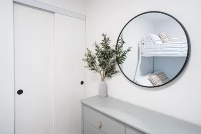 a bathroom with a mirror on a white wall at Qs Hideaway in Mackenzie Village in Revelstoke