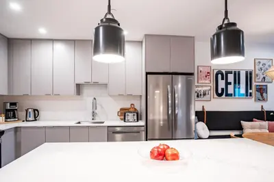 a kitchen with white cabinets and a bowl of fruit on a counter at The Ceili Cottage in Mackenzie Village in Revelstoke