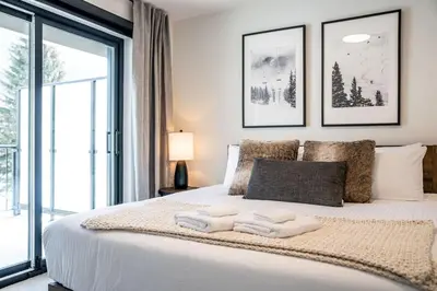 a bedroom with a large bed with towels on it at The Peaks and Birdies in Mackenzie Village, Revelstoke in Revelstoke