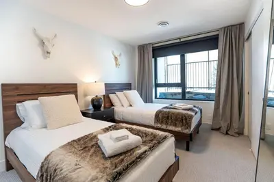 a hotel room with two beds and a window at The Peaks and Birdies in Mackenzie Village, Revelstoke in Revelstoke