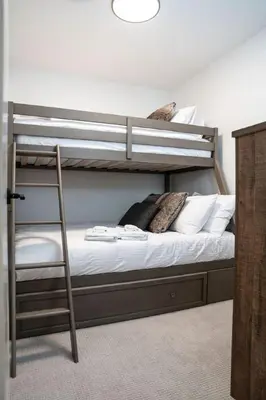 a bunk bed with a ladder in a room at The Peaks and Birdies in Mackenzie Village, Revelstoke in Revelstoke