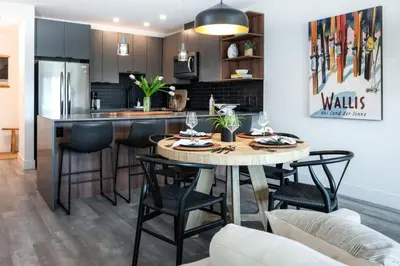 a kitchen and living room with a table and chairs at Alpine Ascent with Hot Tub in Mackenzie Village in Revelstoke
