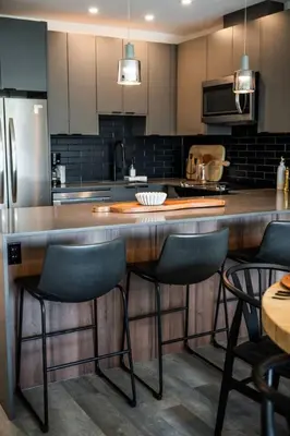 a kitchen with a large wooden counter with stools at Alpine Ascent with Hot Tub in Mackenzie Village in Revelstoke