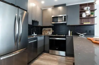 a kitchen with a stainless steel refrigerator and cabinets at Alpine Ascent with Hot Tub in Mackenzie Village in Revelstoke