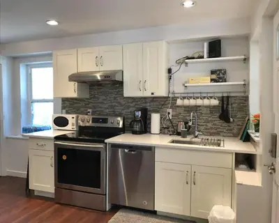 a kitchen with white cabinets and stainless steel appliances at EVE'S Room Connect YVR Downtown UBC in Vancouver