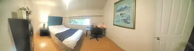 a bedroom with a bed and a table and a door at Quiet Furnished Room Near Transit and Hospital long stays in Surrey