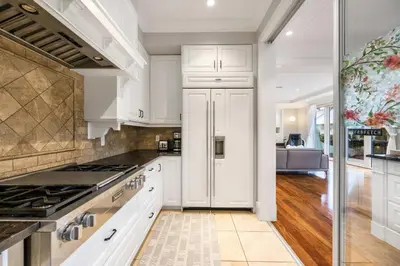 a kitchen with white cabinets and a stove at An Amazing StarHouse in Westside Vancouver in Vancouver
