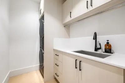a kitchen with a sink and a refrigerator at An Amazing StarHouse in Westside Vancouver in Vancouver