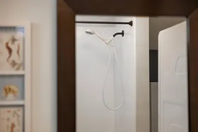 a shower head hanging on a wall in a bathroom at Quiet & Walkable - Stampede, BMO, Nightlife & Eats in Calgary