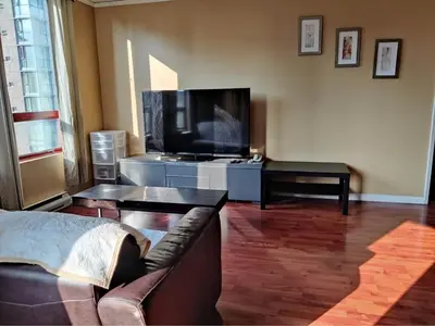 a living room with a couch and a flat screen tv at Comfortable 2-Bedroom Downtown Stay Prime Area in Vancouver
