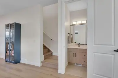 an open kitchen with a staircase and a mirror at Shaganappi 2BR with private Baths, Walk to CTrain, Garage Parking, Full Kitchen in Calgary