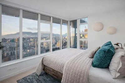 a bedroom with a bed with a view of the city at Downtown 2-Bedroom Apartment with Beautiful City Views in Vancouver